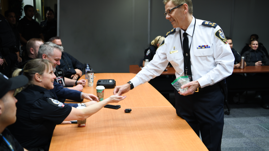 Chief Lipinski hands over badge to officer in conference room 