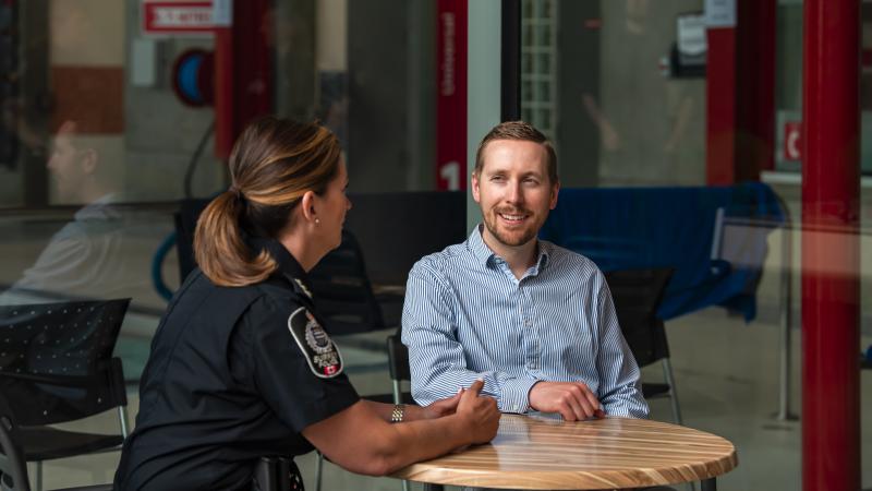 officer speaking with community member at table