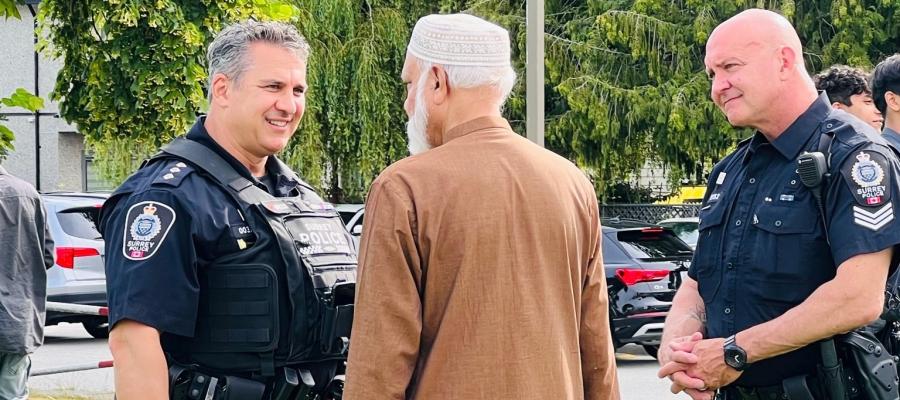 Officers outside speak with man at community engagement 