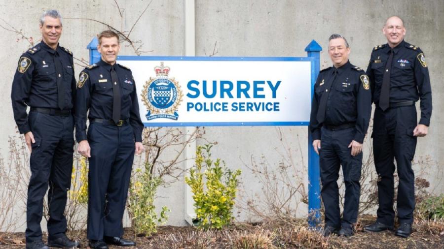 Senior officers in front of SPS sign